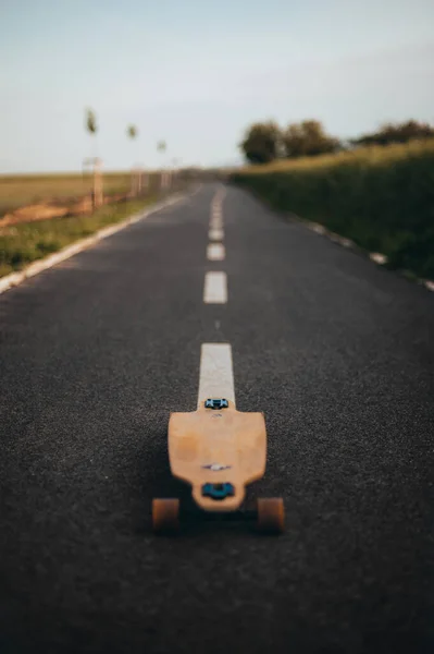 Longboard na środku drogi bez figury. przestrzeń kopiowania.Pionowy baner. Plakat. Plakat Longboard Day. — Zdjęcie stockowe