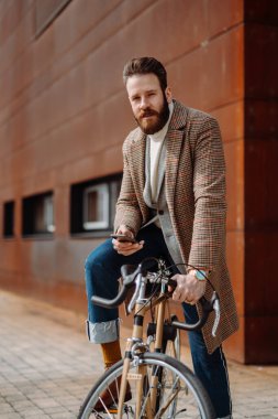 Genç adam mobil uygulamalı akıllı telefon kullanıyor. Modern bir iş alanında yaratıcı bir iş adamı..