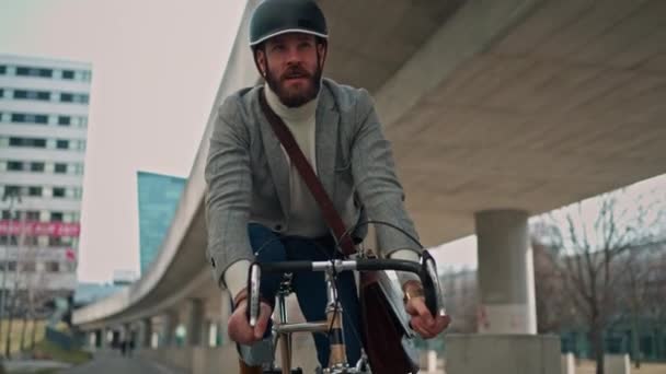 Junger Mann mit Fahrrad und Smartphone vor dem Gebäude. Kreativer Geschäftsmann in einem modernen Geschäftsfeld. — Stockvideo