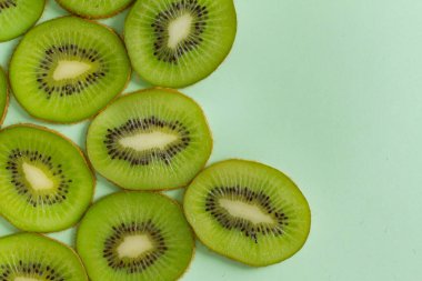 Düz görünüm kivi meyvesi pastel yeşil arka planda izole yatıyordu