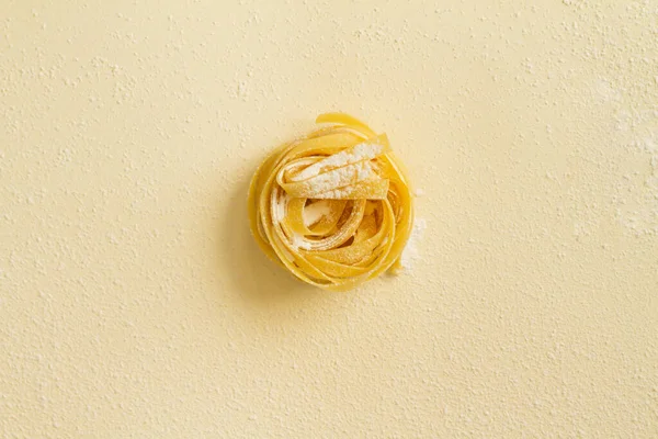 Flat lay top view makaron fettuccine na żółtym pastelowym tle kopiuj przestrzeń — Zdjęcie stockowe