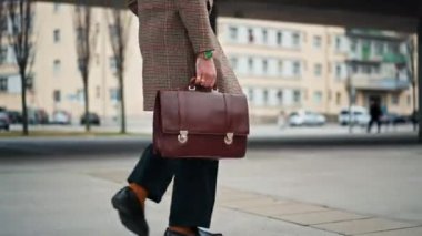 Midsection İşadamı işe yürüyerek gidiyor. Elinde deri bir evrak çantası var. Ofise gidip geliyorum. Toplu taşıma