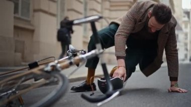 Bisiklet kazası, dizinden yaralanmış. Şehirde bir bisiklet kazası. Adam bisikletten düştü.