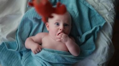 Kameraya gülümseyen, tatlı, causian bir oğlan çocuğu oyuncağa bakar ve çok sevinir. dikey video