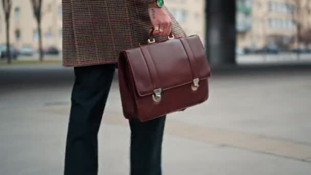 Закрыть молодой бизнесмен собирается на работу пешком. держа кожаную сумку в руке. Коммутируюсь с офисом. Общественный транспорт — стоковое видео