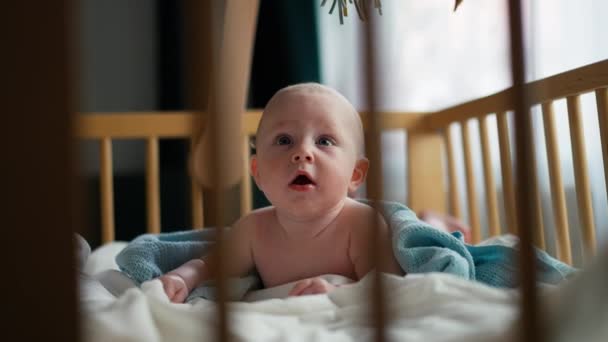 Bébé garçon tout-petit rampant dans la crèche de la chambre d'enfant à la maison. regarder et sourire à la caméra — Video