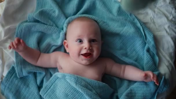 Adorable petit garçon tout-petit, souriant à la caméra, garçon riant et heureux au lit, Toy overhead — Video