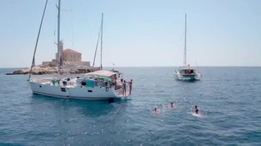 Yelkenliden atlayan genç arkadaşlar. Yatçılık. Yelkenli partisi günü. Yaz lüks tekne gezisi