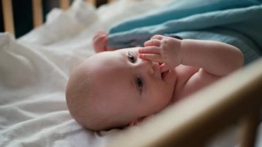 Küçük tatlı Causian oğlan, kameraya gülümsüyor, çocuk sırt üstü yatıyor ve dönüyor.