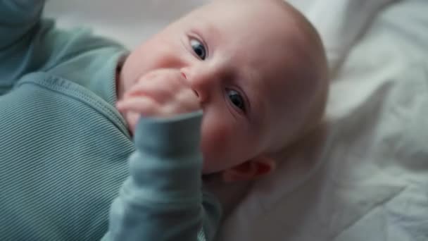 Petit garçon tout-petit aux yeux bleus, souriant à la caméra, garçon riant et heureux au lit, Toy overhead — Video
