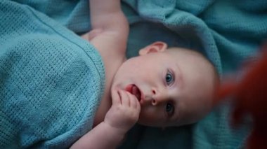  Küçük çocuk mavi gözlü, kameraya gülümseyen, yatakta gülen ve mutlu bir çocuk, başımızın üstünde oyuncak