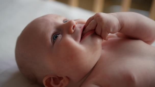 Bebê criança deitado no cobertor azul, sorrindo e olhando para longe. — Vídeo de Stock