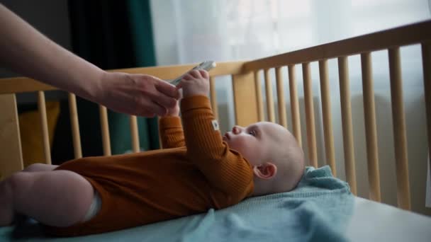 Bebê criança segurando smartphone. Assistir a um vídeo no smartphone. — Vídeo de Stock