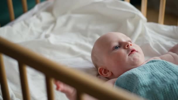 Bébé tout-petit couché sur la couverture bleue, bébé pleurant. — Video