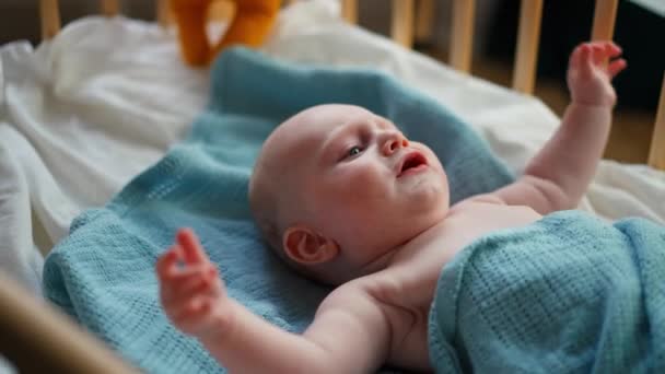 Μωρό νήπιο ξαπλωμένο στη μπλε κουβέρτα, μωρό κλαίει. — Αρχείο Βίντεο