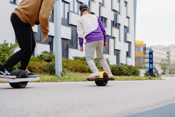 Καβαλάρηδες με ηλεκτρικά skateboards βόλτα στα πεζοδρόμια. Αντιγραφή χώρου. — Φωτογραφία Αρχείου