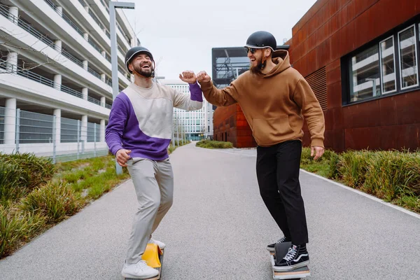 two men on electronic skateboards salute their elbows. the future live style. Urban Background