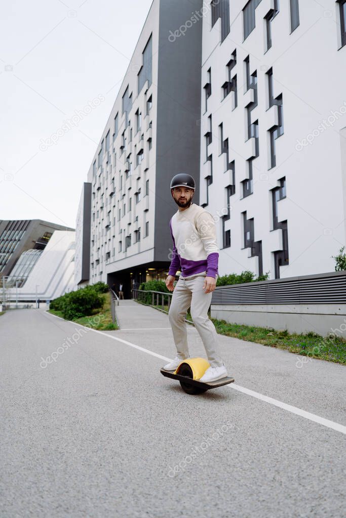 Young skater guy riding outside. Men enjoying extreme ride outdoors. Urban Background