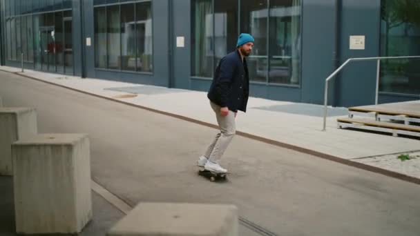 Muž jezdí na skateboardu. Moderní budova v pozadí — Stock video