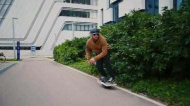 Miğferli genç havalı adam tek tekerlek tahtası kullanıyor. Kentsel bir arka planda tek teker binicisi. 