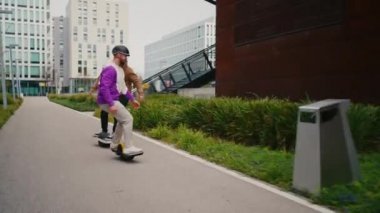 İki adam gelecekteki Segway 'e gidiyor. Elektrikli kaykay ekibi. Gelecekteki yaşam tarzı. Şehir Arkaplanı