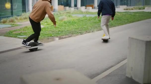 Riders on electric skateboards ride on the sidewalks. — стоковое видео