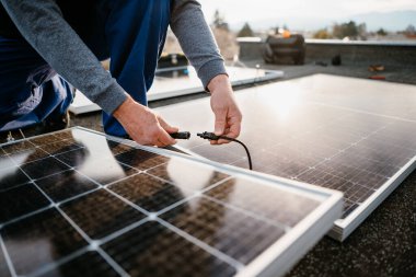 İşçi güneş enerjisi panelleri kuruyor. Alternatif enerji sistemi. eko kavramı