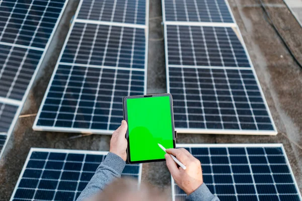 Engineering use a tablet and checking solar power system. Holding tablet with green screen — Stock Photo, Image