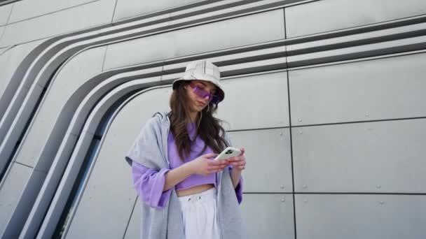 Cute attractive woman using phone in urban city buildings. Portrait, young, internet, cellphone, street, beautiful, travel, mobile, stylish. — Video Stock