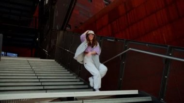 Beautiful and happy European girl having fun dancing break dance hip hop freestyle outdoors.