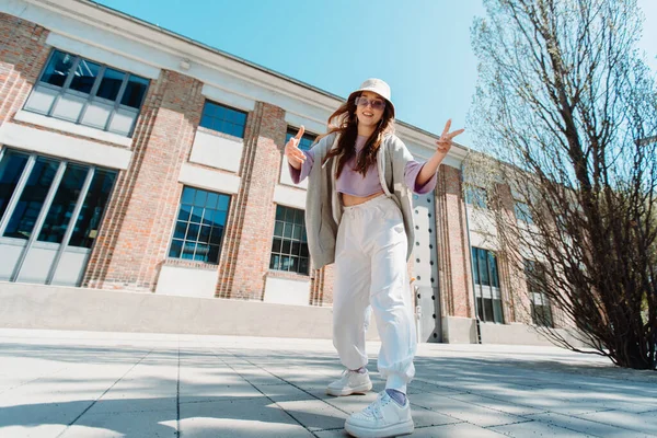 Kaunis nuori valkoihoinen tyttö hip hop asussa yllään tanssia musiikin alla kadulla. — kuvapankkivalokuva