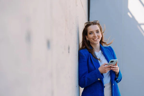 Woman manager looking at camera. Holding smartphone. Copyspace. Isolated – stockfoto