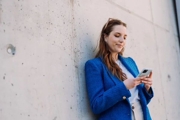 Modern businesswoman in blue suit using mobile phone. Copyspace — ストック写真