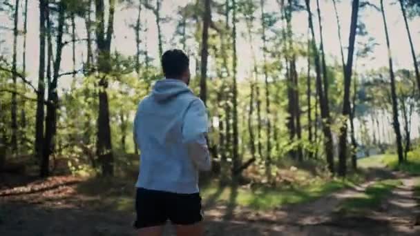 Suivez le tir. Jeune homme athlétique courant dans la forêt — Video