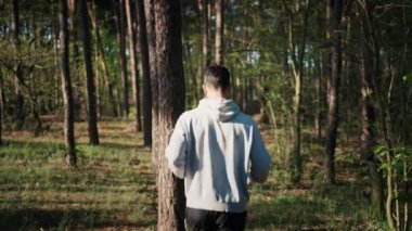 Ormanda koşan koşucunun spor giyim kuşamının arka görüntüsü. Sabah rutini. Yavaş çekim 4K