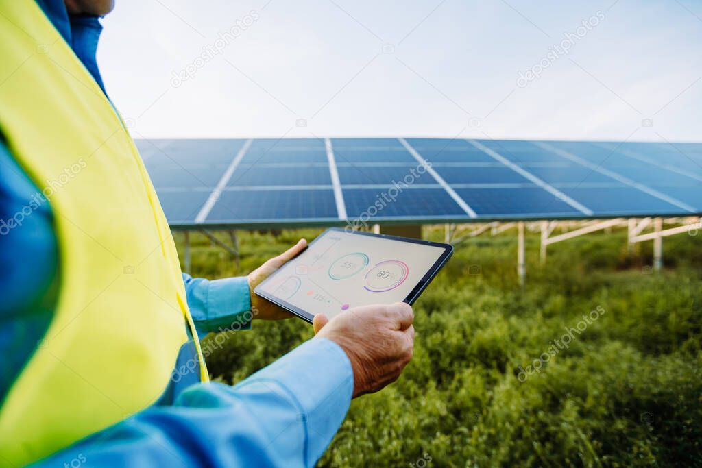 Worker using tablet for setting solar system. Eco concept. High quality photo