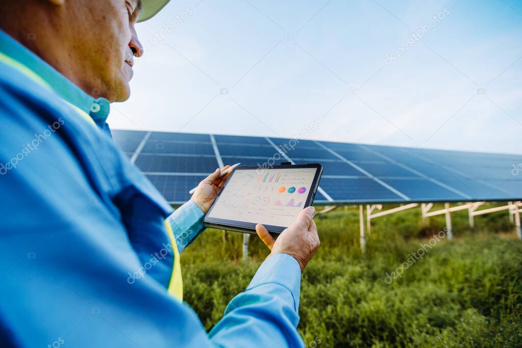 Engineer is holding tablet. Settings of solar system. Alternative energy concept. High quality photo