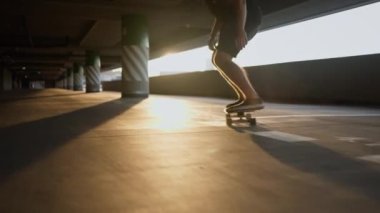 Park alanından kaykayla daha hızlı geçen yetenekli kaykaycının yakın görüntüsü. Genç trend adam kaykayla antrenman yapıyor. Ekstrem spor konsepti