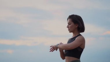 Trail running runner girl finished her run and looking at heart rate monitor smart watch in the mountain hill. Female athlete jogger training in woods concept