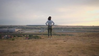 Girl runner feeling free and enjoying view of mountains. Woman standing on the hill after jogging. Adventure, sport, activity, wanderlust concept