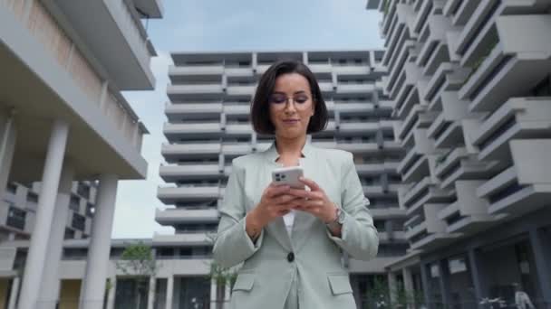 Female Realtor Wearing Formal Suit Holding Smartphone While Going Financial — Video Stock