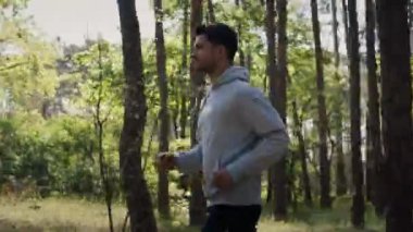 Man jogging in forest woods while training and exercising for trail run. Fitness healthy lifestyle concept with male athlete trail runner. Movement concept 