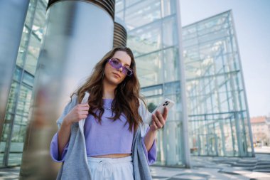 Kameraya bakıp cep telefonu tutan havalı bir genç kız. - Evet. Yüksek kalite fotoğraf