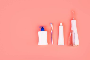 Düz kompozisyon, manuel diş fırçası, sulama, diş macunu ve renkli arka planda ağız temizliği ürünleri. Düz konsept. sözlü bakım konsepti