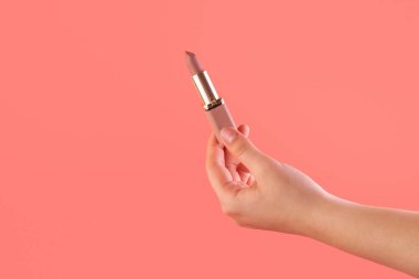 Ruj tutan kadın eli. Maquillage için ekipman. Makyaj ve vizör. Metin ya da yaratıcı tasarım için yer. Model stili. Kozmetik ve güzellik konsepti. Pembe üzerine izole edilmiş..