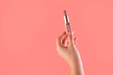 Ruj tutan kadın eli. Maquillage için ekipman. Makyaj ve vizör. Metin ya da yaratıcı tasarım için yer. Model stili. Kozmetik ve güzellik konsepti. Pembe üzerine izole edilmiş..