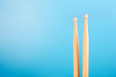 Mavi arka plandaki bagetleri kapatın. Davul dersleri konsepti, müzik aleti dersleri, metin için yeri olan online davul dersleri..