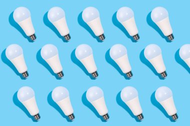 İzole edilmiş mavi arka plandaki lamba desenlerini kapat. Enerji verimliliği kavramı. Düz yatıyordu. Ekolojiyi kavra, dünyayı kurtar, fikri, enerjiyi, ekonomiyi, tasarrufu. Dünya günü.