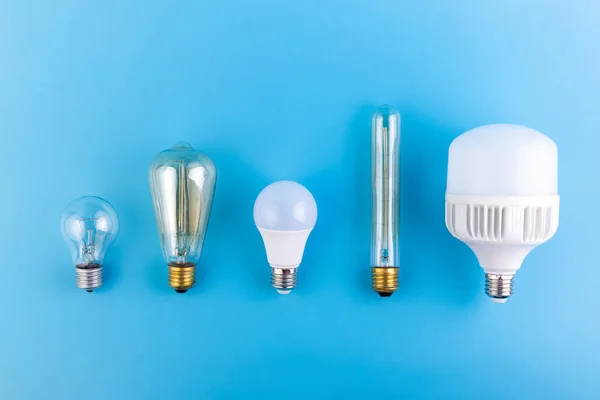 Kurşuni lambaları kapatın ve Edison lambaları izole edilmiş mavi arka planda düz yatar. Enerji verimliliği kavramı. Düz yatıyordu. Ekolojiyi kavra, dünyayı kurtar, fikri, enerjiyi, ekonomiyi, tasarrufu. Dünya günü.