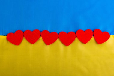 Kırmızı kalp Ukrayna ulusal bayrağında mavi-sarı renkli arka planda. Ukrayna halkının Rusya 'yla savaşa katılma kavramı. Savaş konsepti değil